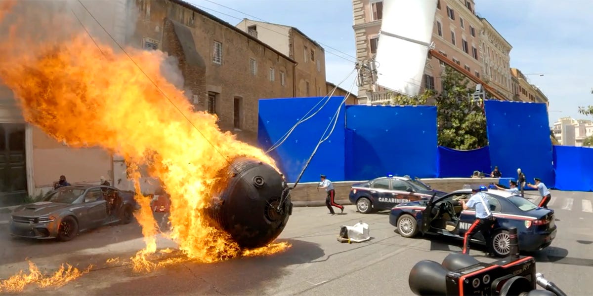 A flaming metal ball rolls past a camera vehicle during production of the Rome chase in Fast X.