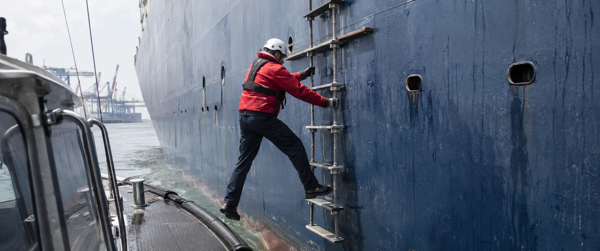 Fully AI-generated fictional action frame of a harbour pilot transferring from a small launch to the exterior ladder of a cargo vessel.