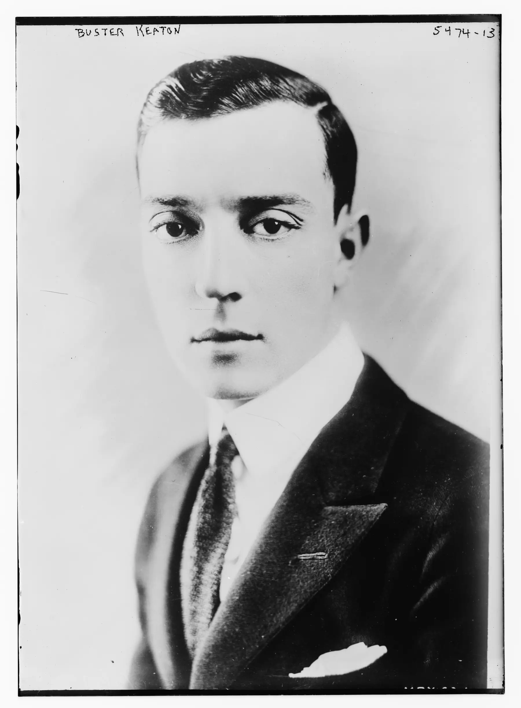 Buster Keaton faces the camera in a formal black-and-white Bain News Service portrait.