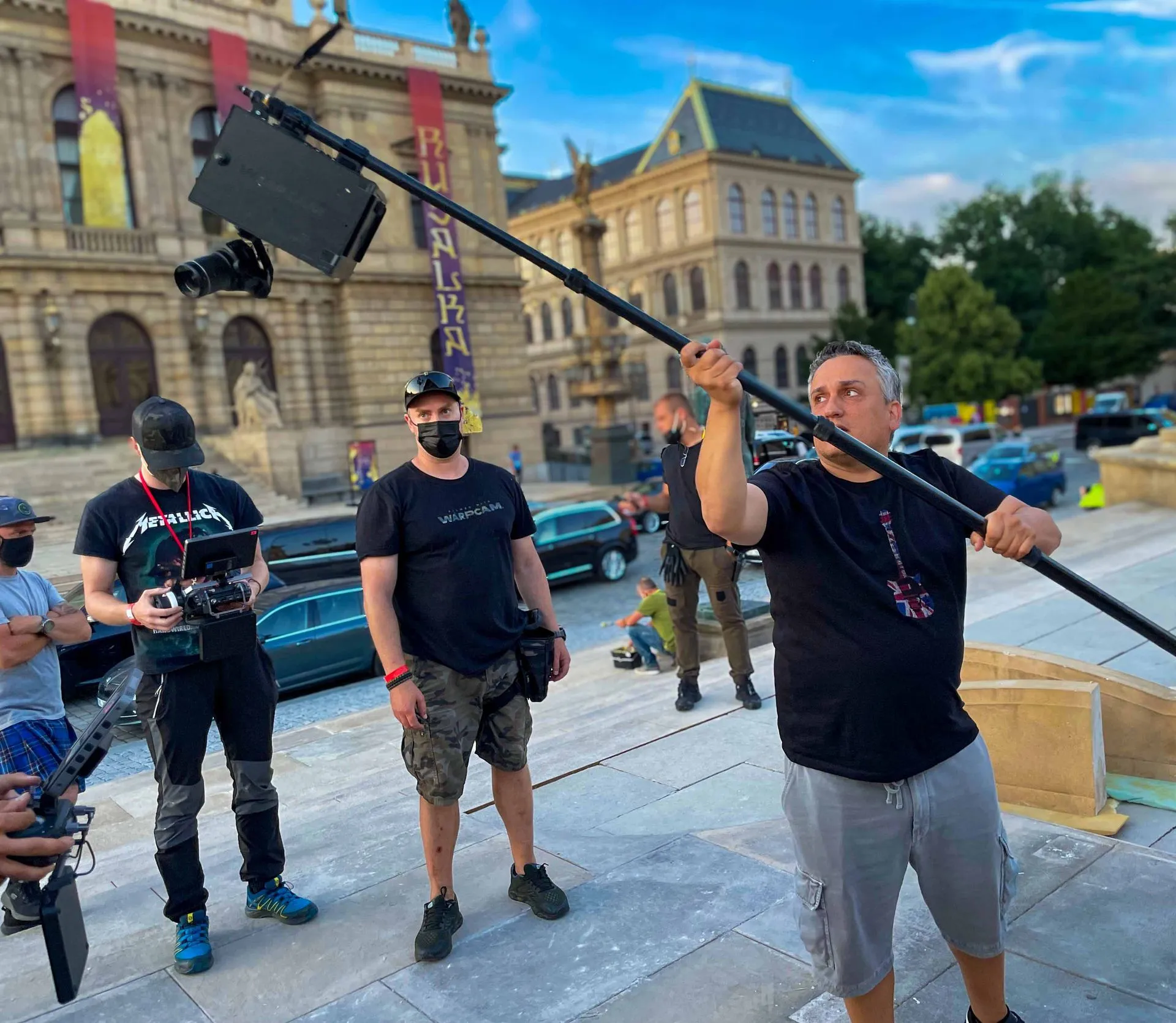 Director Joe Russo holds a compact pole-mounted stabilized camera prototype on the Prague set of The Gray Man.