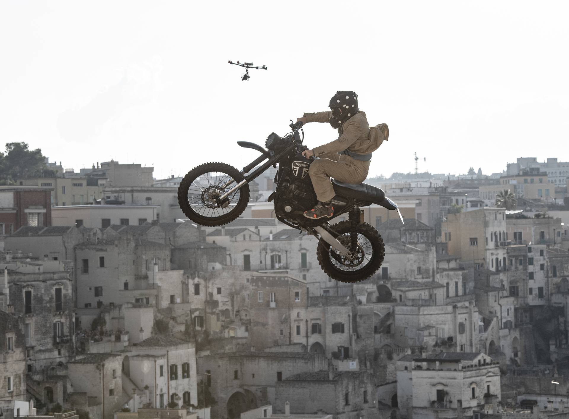 Stunt rider Paul Edmondson is airborne on a Triumph motorcycle above Matera during filming of No Time To Die.