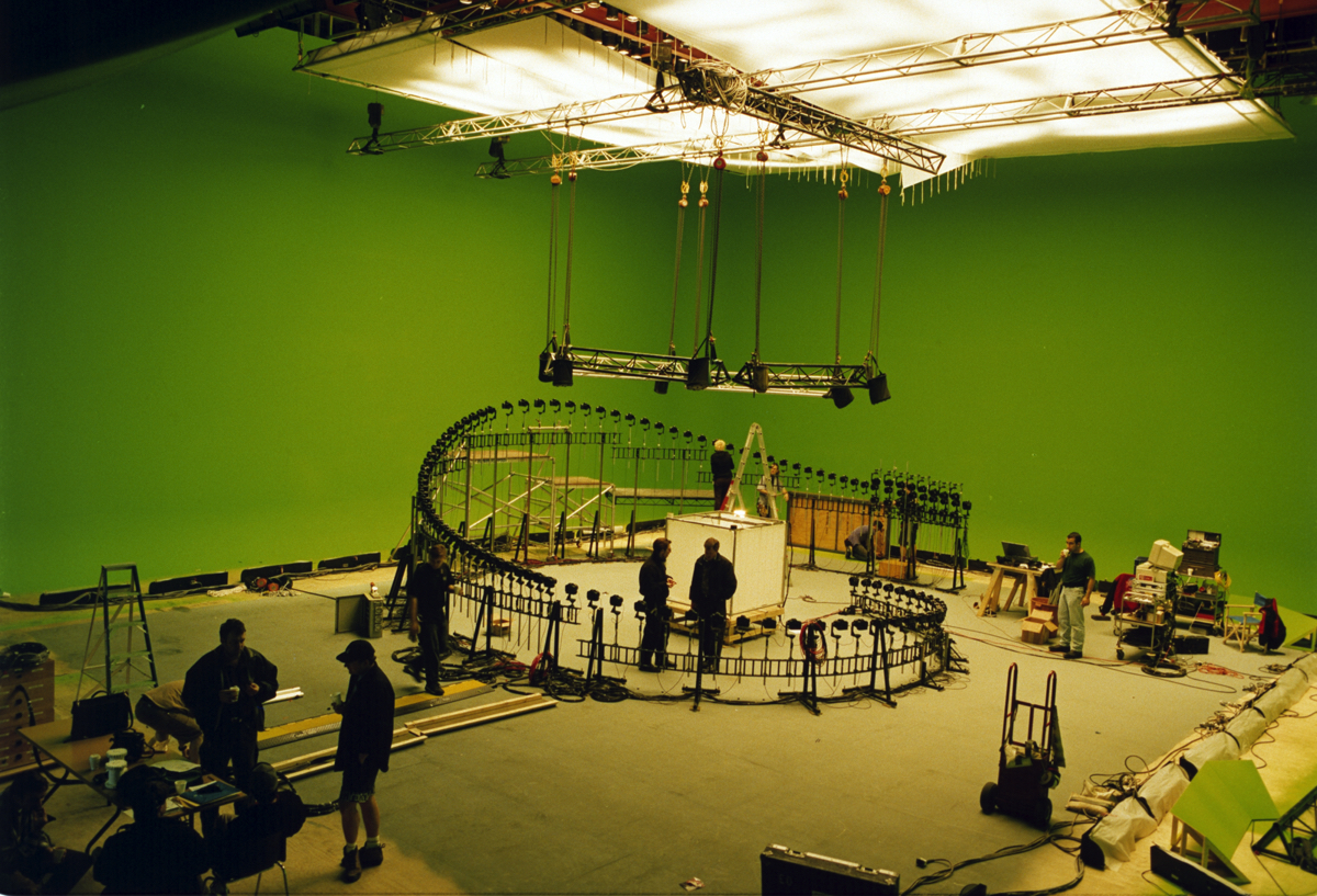 Crew members stand inside the curved still-camera array built for the original bullet-time photography in The Matrix.