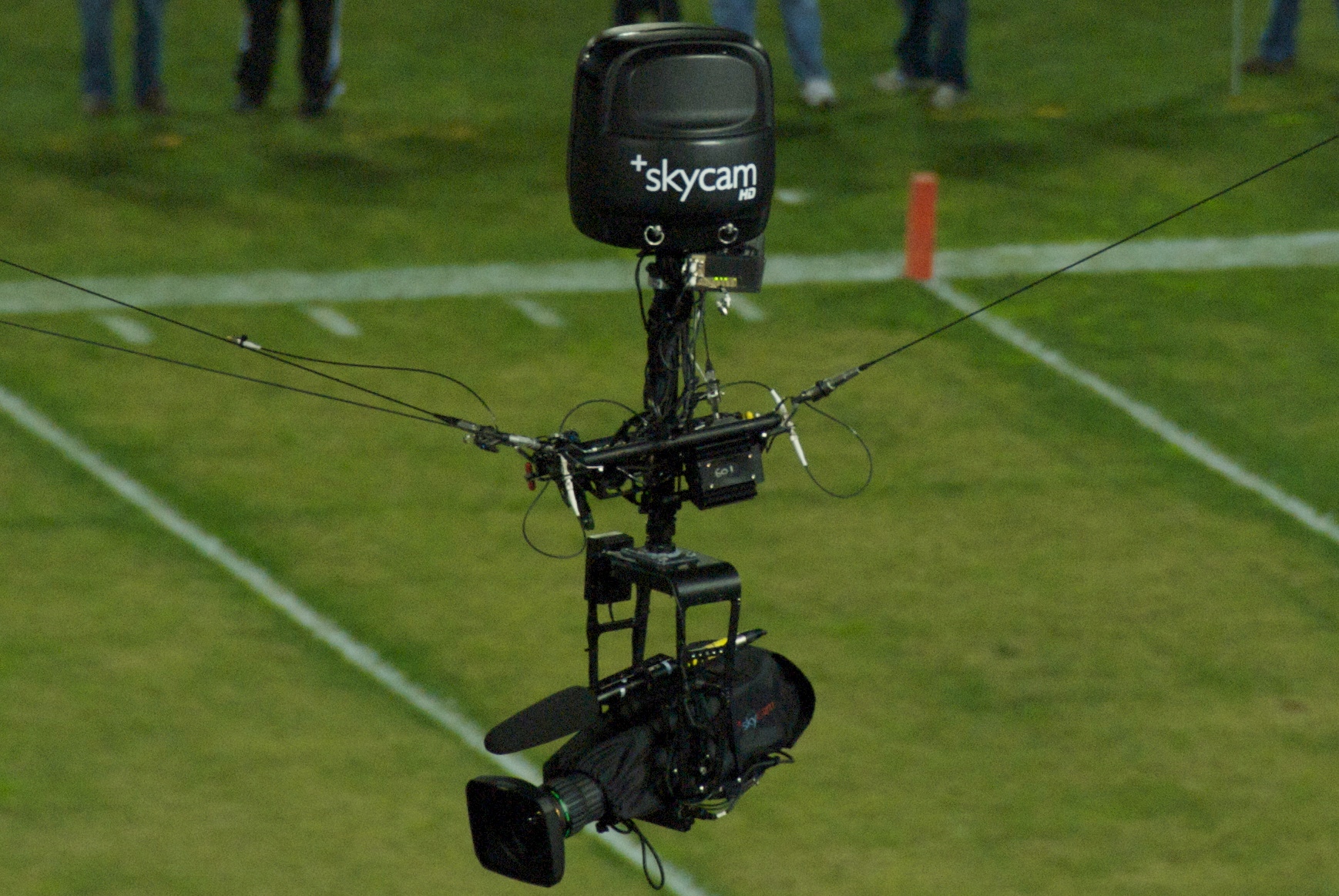 Close view of a Skycam camera carrier suspended from cables above Stanford Stadium.