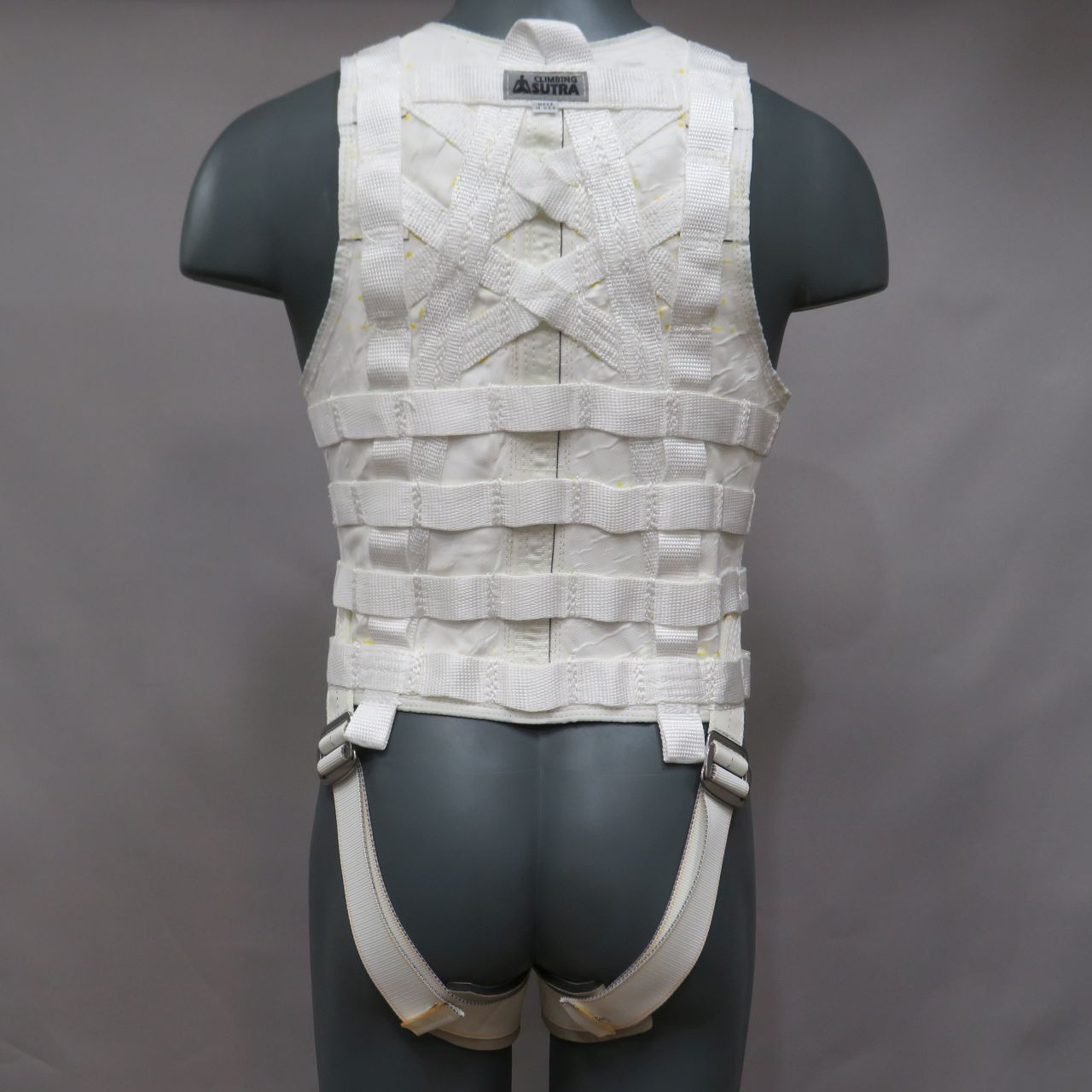 Rear view of a black low-profile Climbing Sutra Spectra-Titanium stunt vest showing reinforced webbing and multiple pick points.