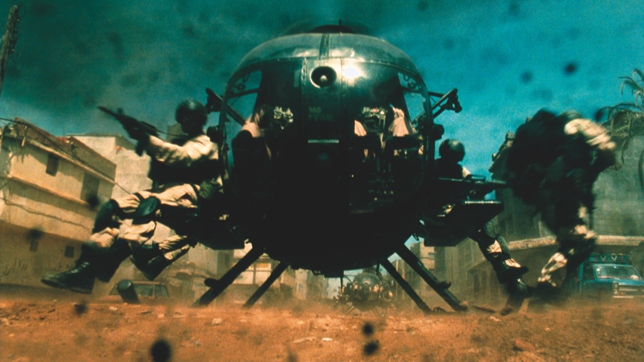 Soldiers exit both sides of a hovering Black Hawk helicopter into a dusty urban street in Black Hawk Down.